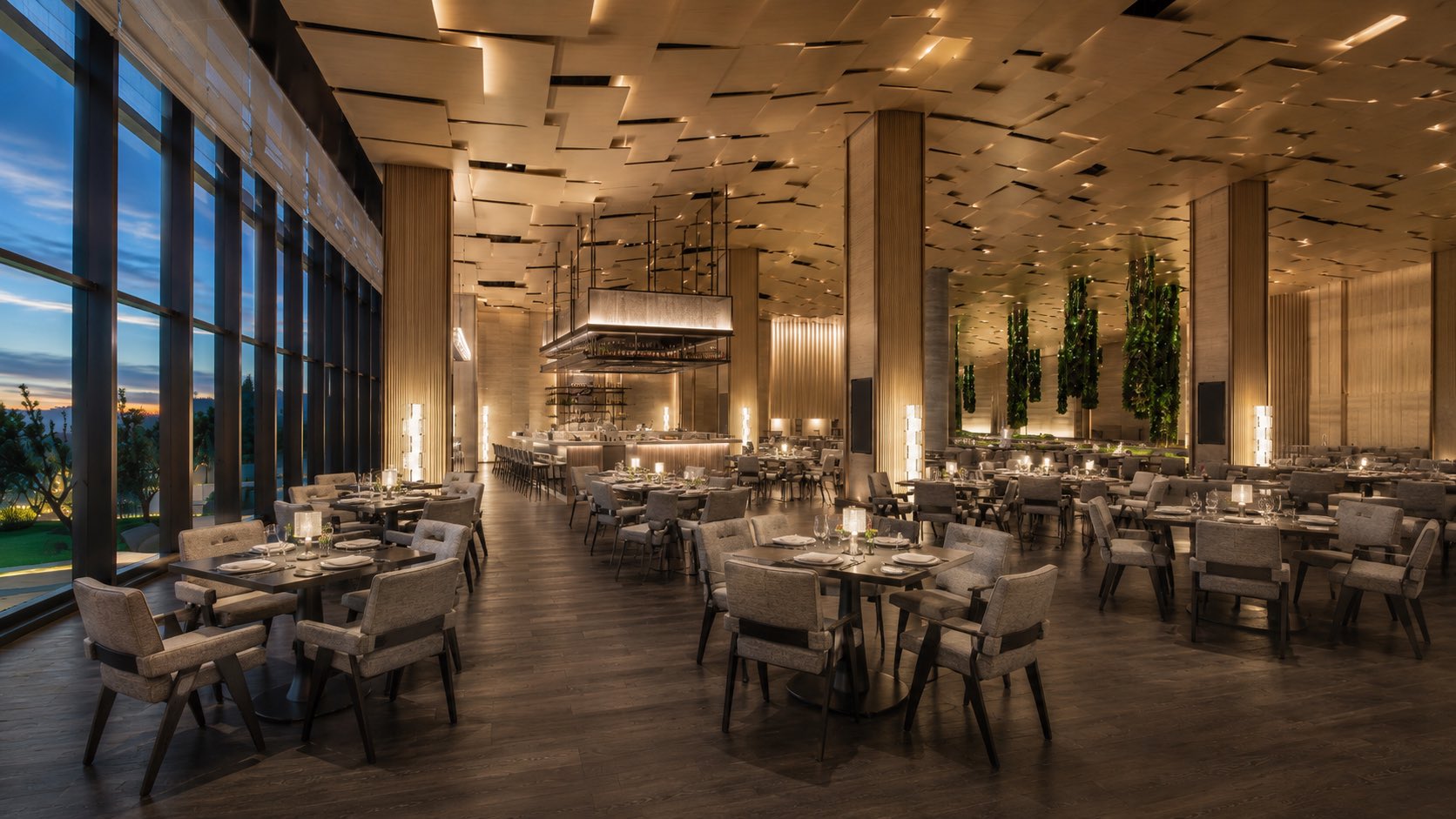 Bright upscale hotel restaurant with upholstered dining chairs, tables and refined hospitality furniture